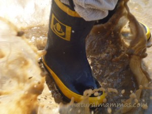 mud boots splashing in puddles playing in nature