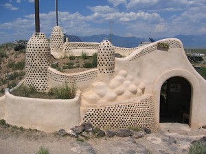 Adobe plastered earthship with towers in Taos